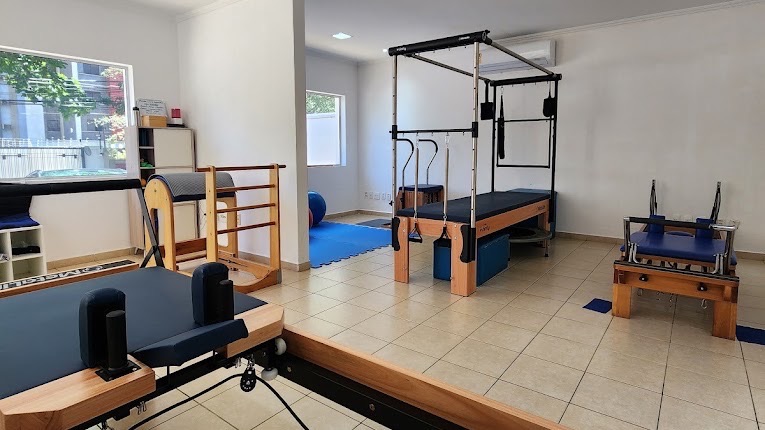 Estúdio de Pilates da clínica com aparelhos reformer e cadillac